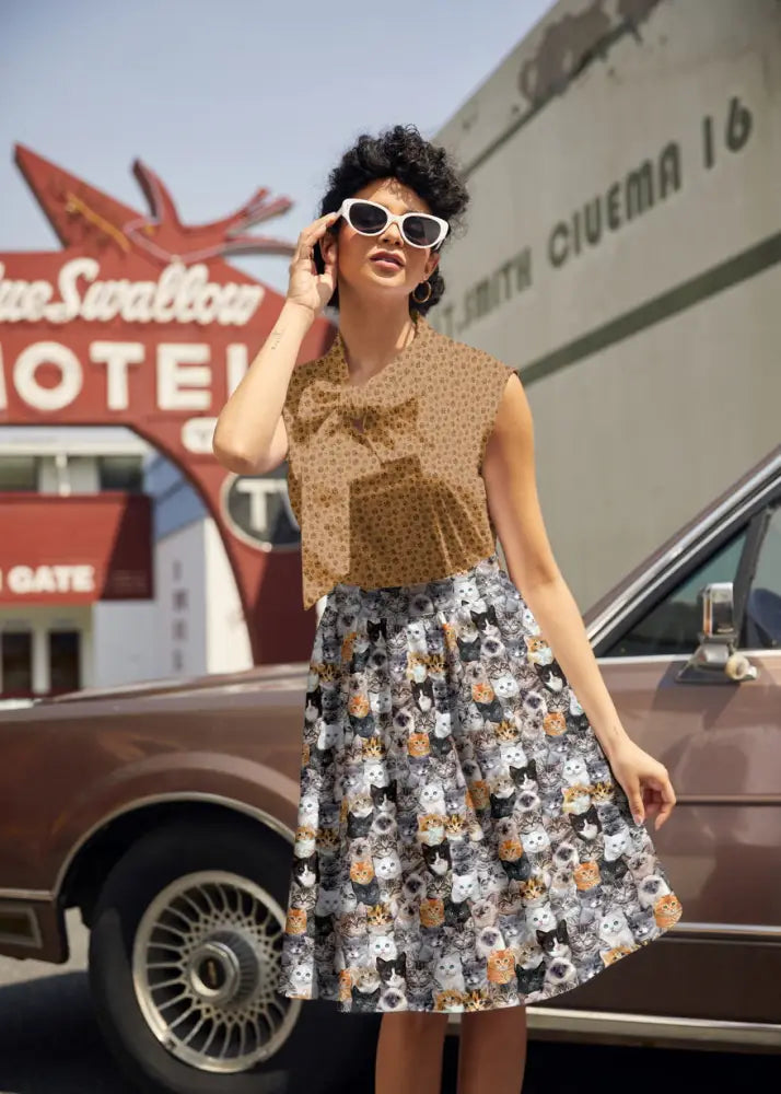 A woman wears a vintage realistic cat print cotton a-line skirt with pockets paired with a brown polka-dot sleeveless top