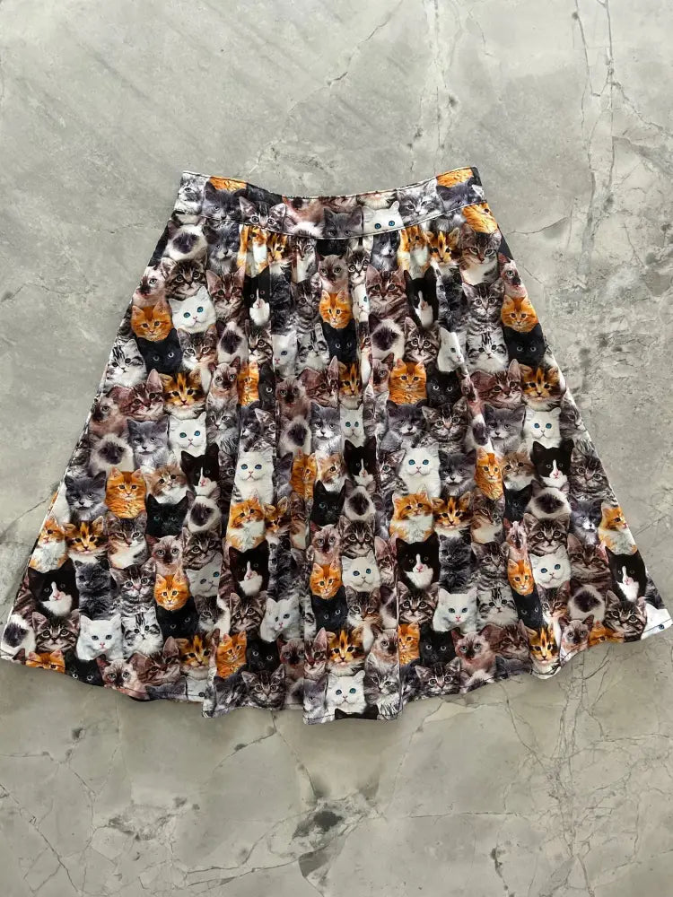 A pleated vintage realistic cat print cotton a-line skirt with pockets featuring colorful cat faces all over