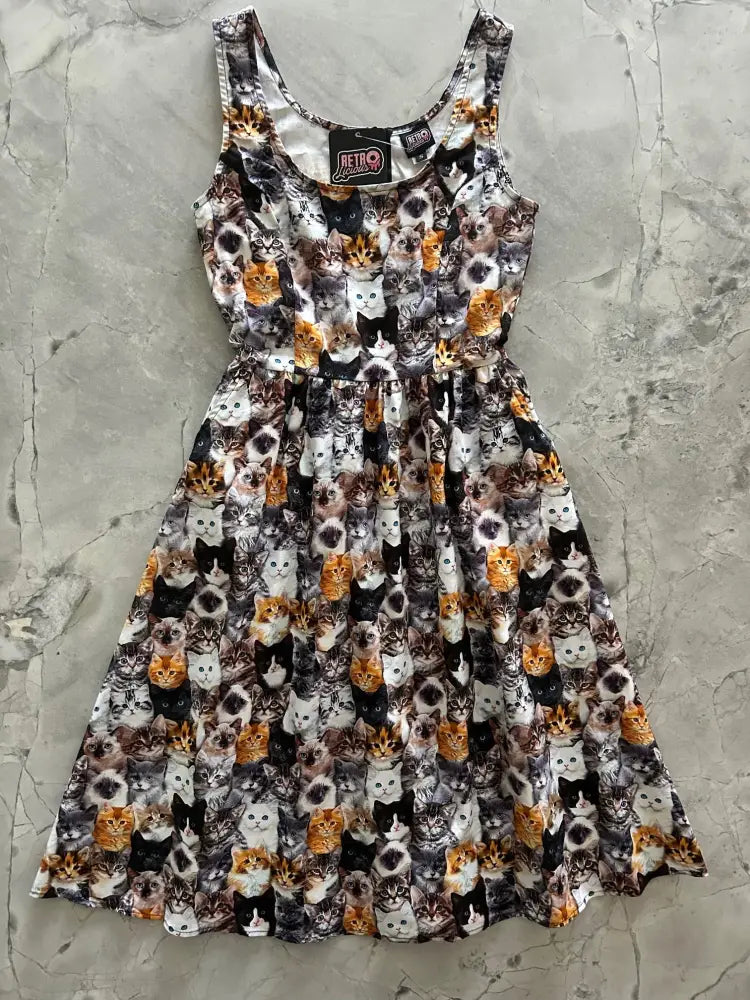 A sleeveless vintage midi dress with pockets featuring a colorful realistic cats print in multiple patterns