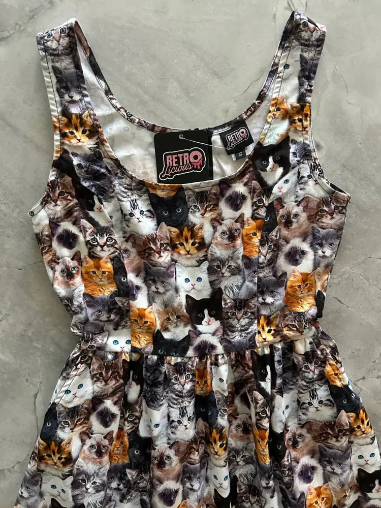 A sleeveless vintage midi dress with pockets featuring a vibrant all-over print of realistic cats in various breeds and colors