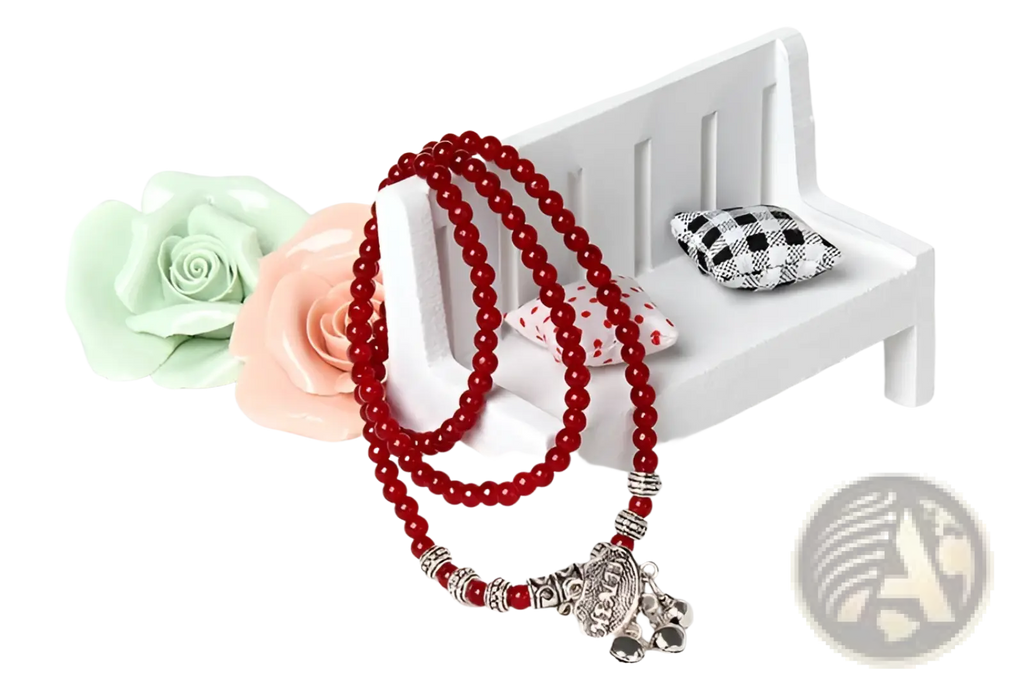 Red agate good luck bracelet featuring red beaded rosary with silver-toned accents and detailed elephant pendant