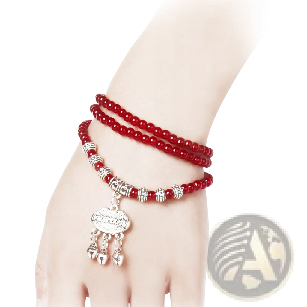 Red agate good luck bracelet featuring red beads with silver-toned engraved protect charms and a dangling pendant