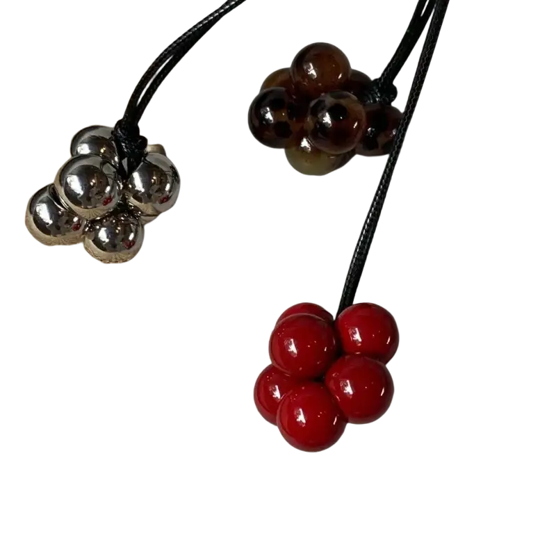 Red bead cluster pendant necklace by Guja featuring glossy red and metallic silver cherry-shaped beads on black cord