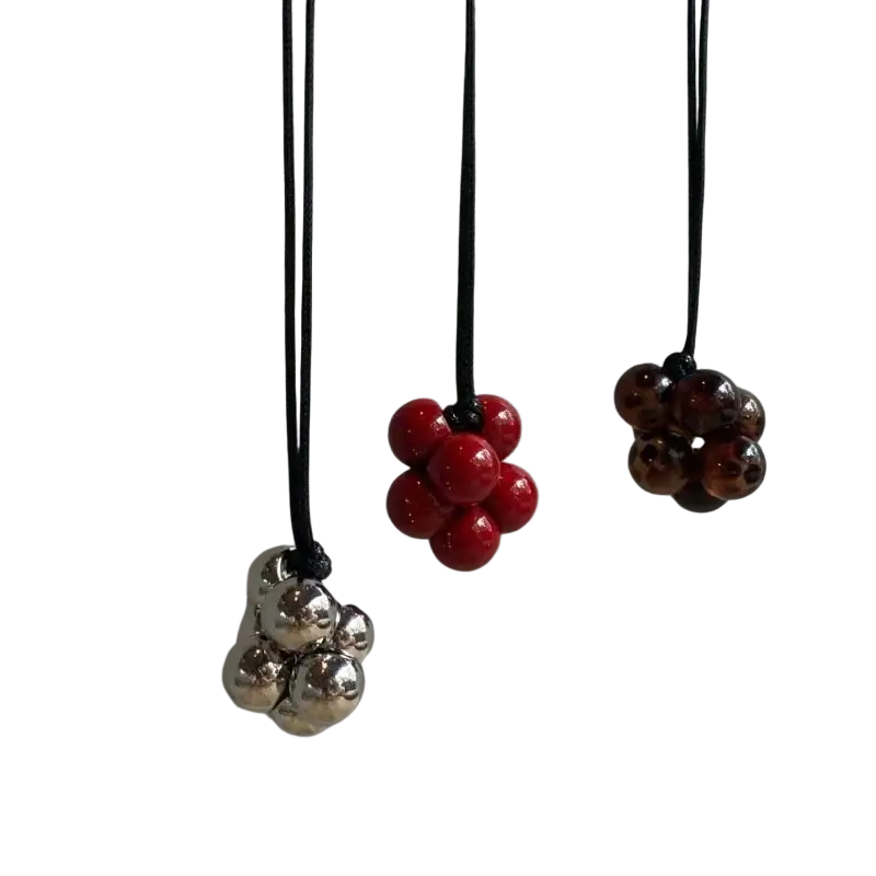 Three hanging bead cluster pendants in silver, vibrant red, and dark brown on black cord straps for necklace use