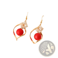 Gold-toned drop earrings with a red spherical bead in a crystal-adorned open swirling geometric frame