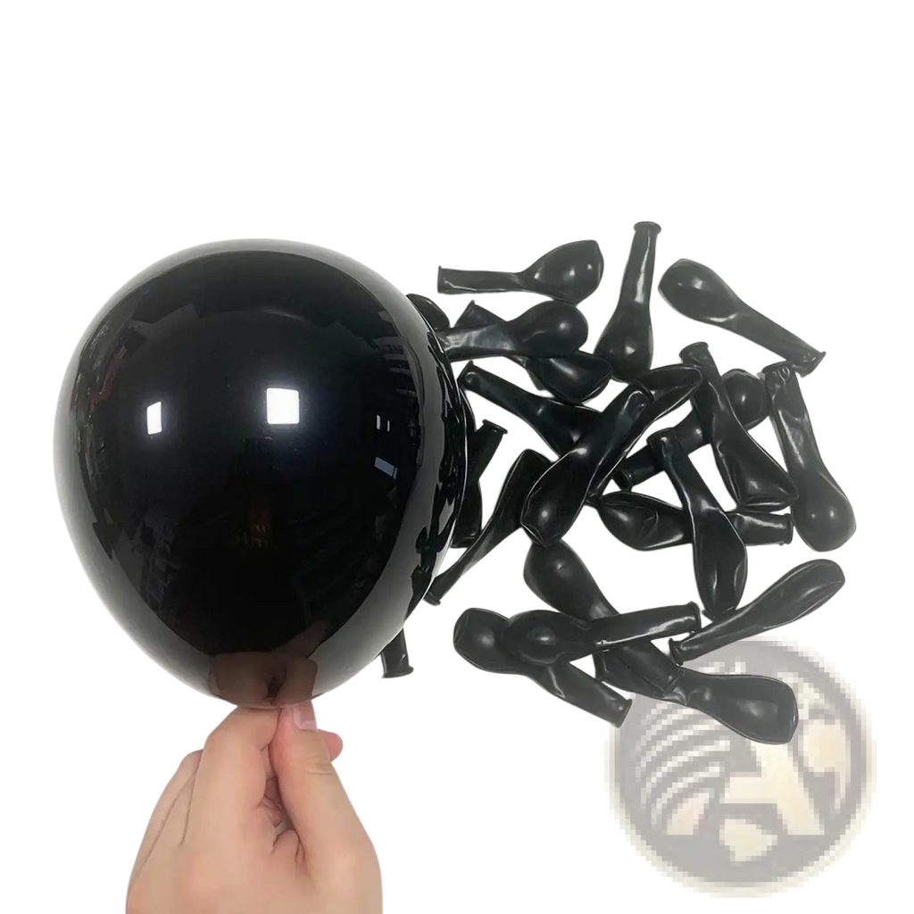 A hand holding a glossy black latex balloon with deflated black balloons for red black balloon garland arch kit