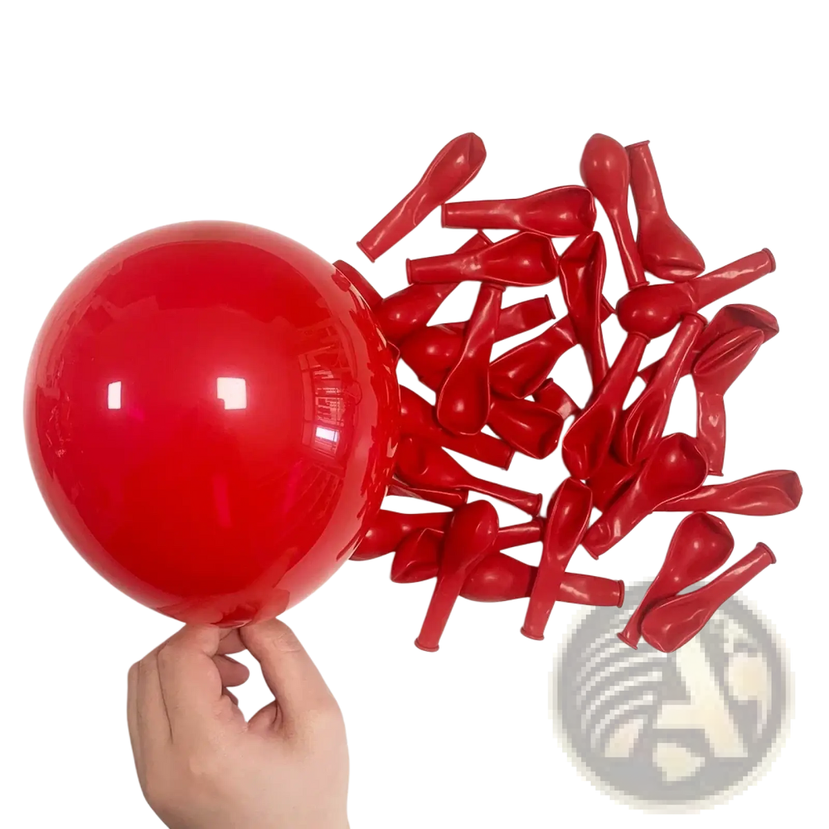 A single inflated red latex balloon held by hand among deflated red balloons from a red black balloon garland arch kit