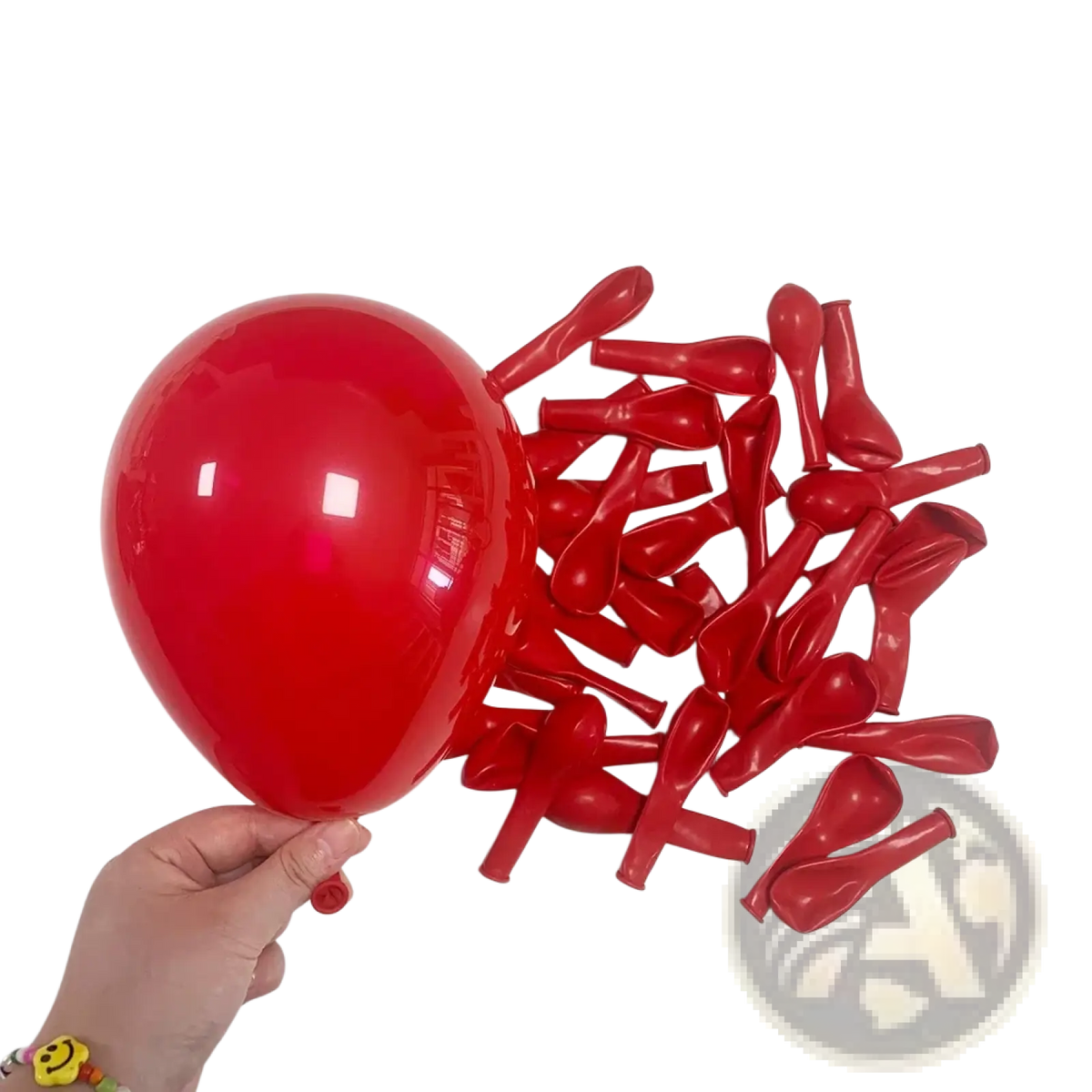 A single inflated red latex balloon held by hand with deflated red balloons for red black white balloon set party decor