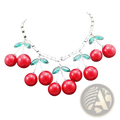 Red cherry statement necklace featuring red cherry design with crystal choker, silver-toned chain, and green leaf accents