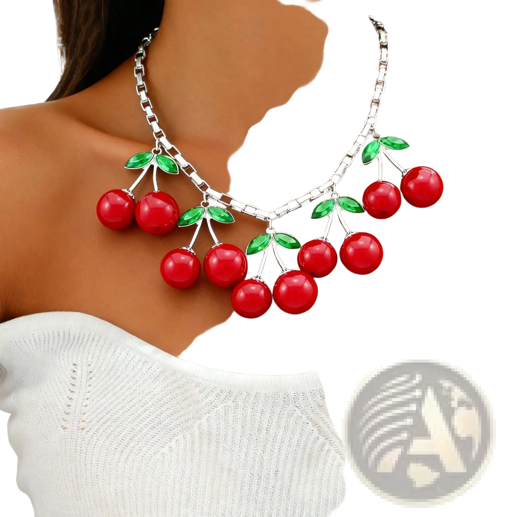 Red cherry statement necklace featuring glossy resin cherries and green enamel leaves on a silver-toned chain