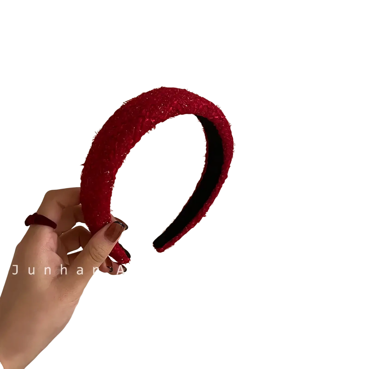 Red knitted headband for women with a vibrant red textured fuzzy exterior and smooth black interior lining