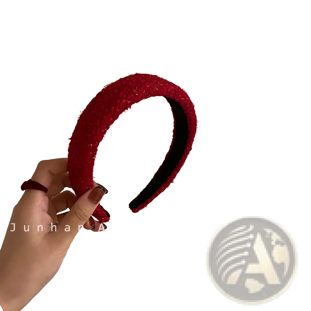 Red knitted headband for women with a vibrant red textured fuzzy exterior and smooth black interior lining