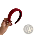 Red knitted headband for women with a vibrant red textured fuzzy exterior and smooth black interior lining