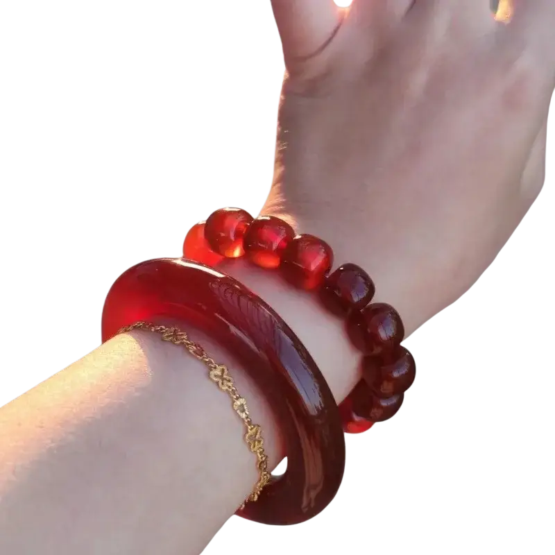 A glossy deep red jade bangle bracelet for women with a smooth classic round style worn on a wrist