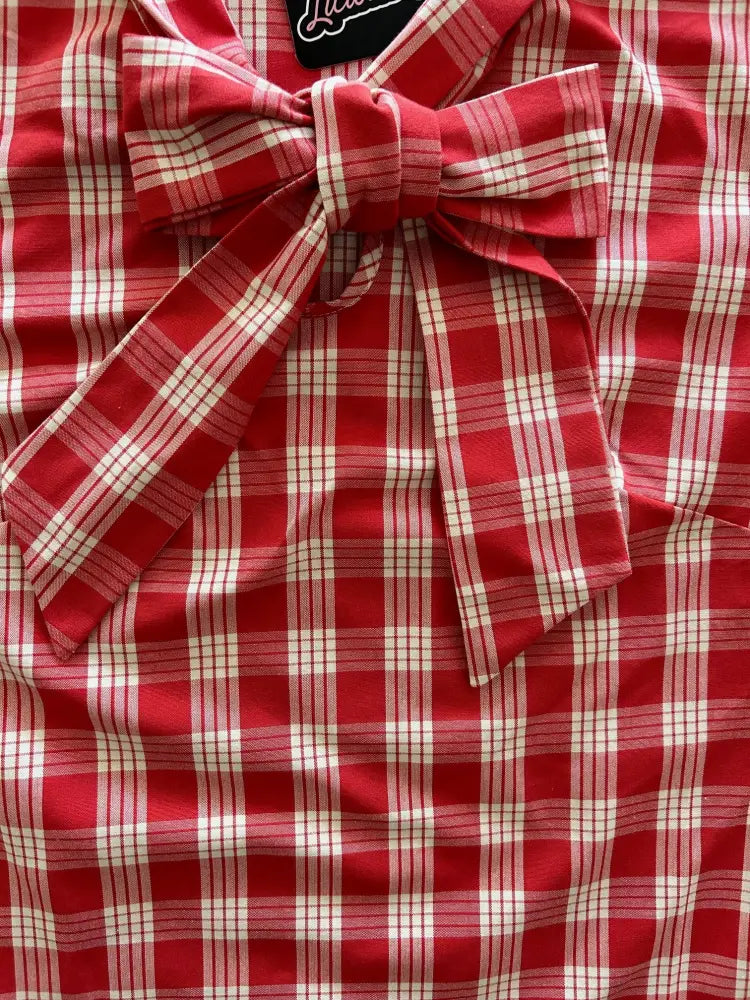 Vintage red and white plaid sleeveless blouse featuring a prominent bow at the neckline in a lightweight fabric