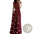A woman wearing a sleeveless red polka dot French formal maxi dress with large white dots and floor-length design