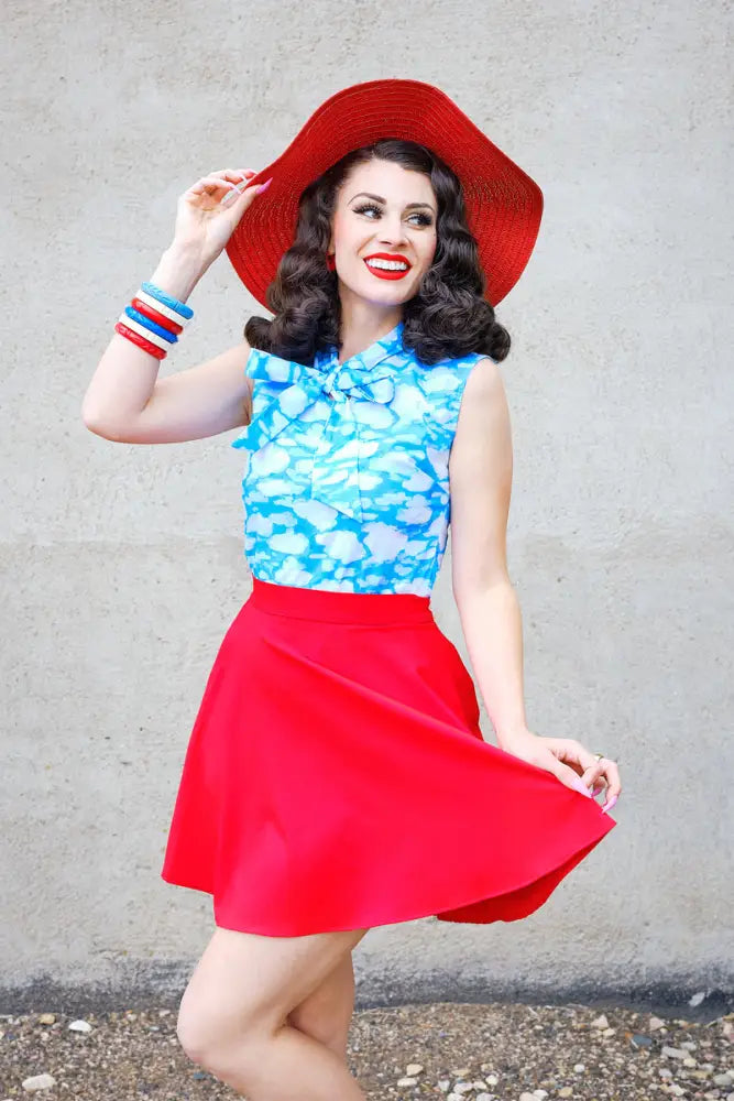 Vibrant red wide-brimmed straw hat paired with a vintage red skater skirt featuring pockets and an elastic waist