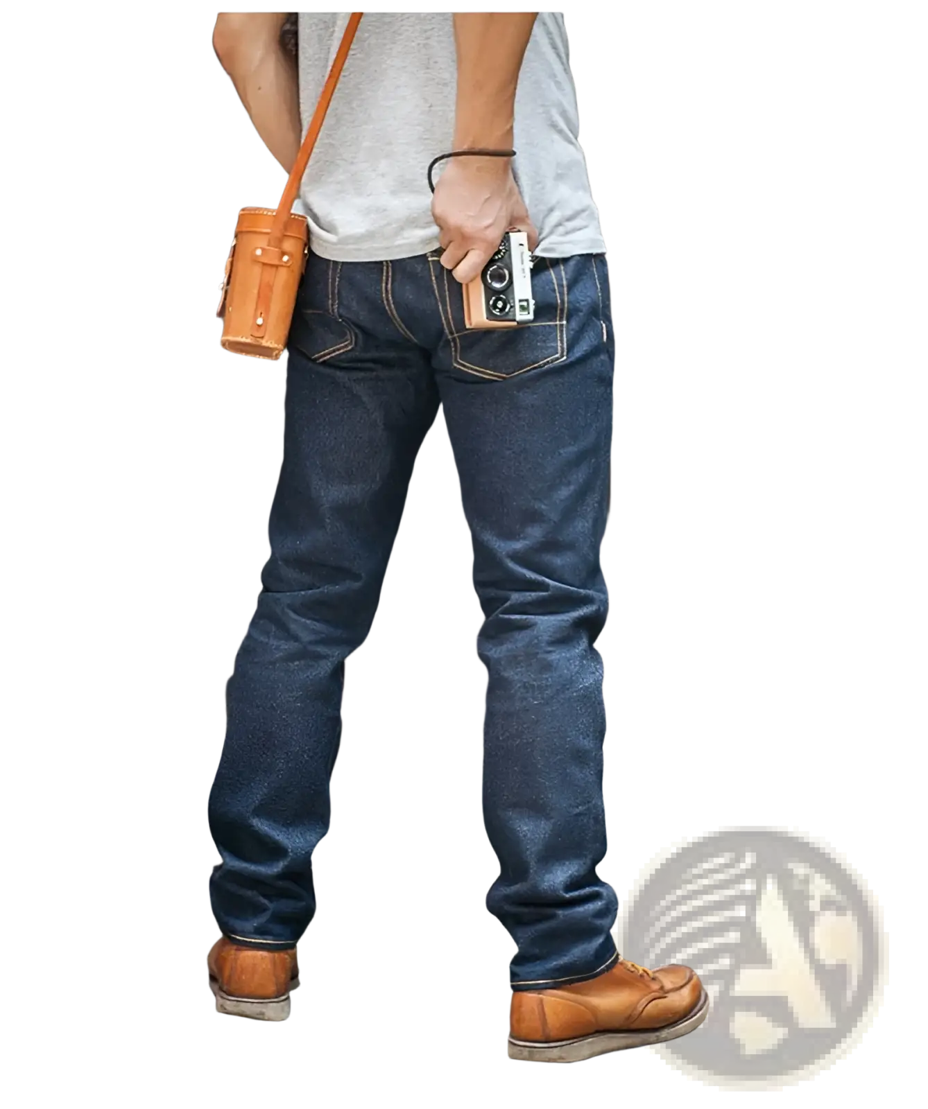 A tan leather camera pouch with sturdy strap and stitching worn over the shoulder paired with red tornado 16oz slim straight selvedge jeans