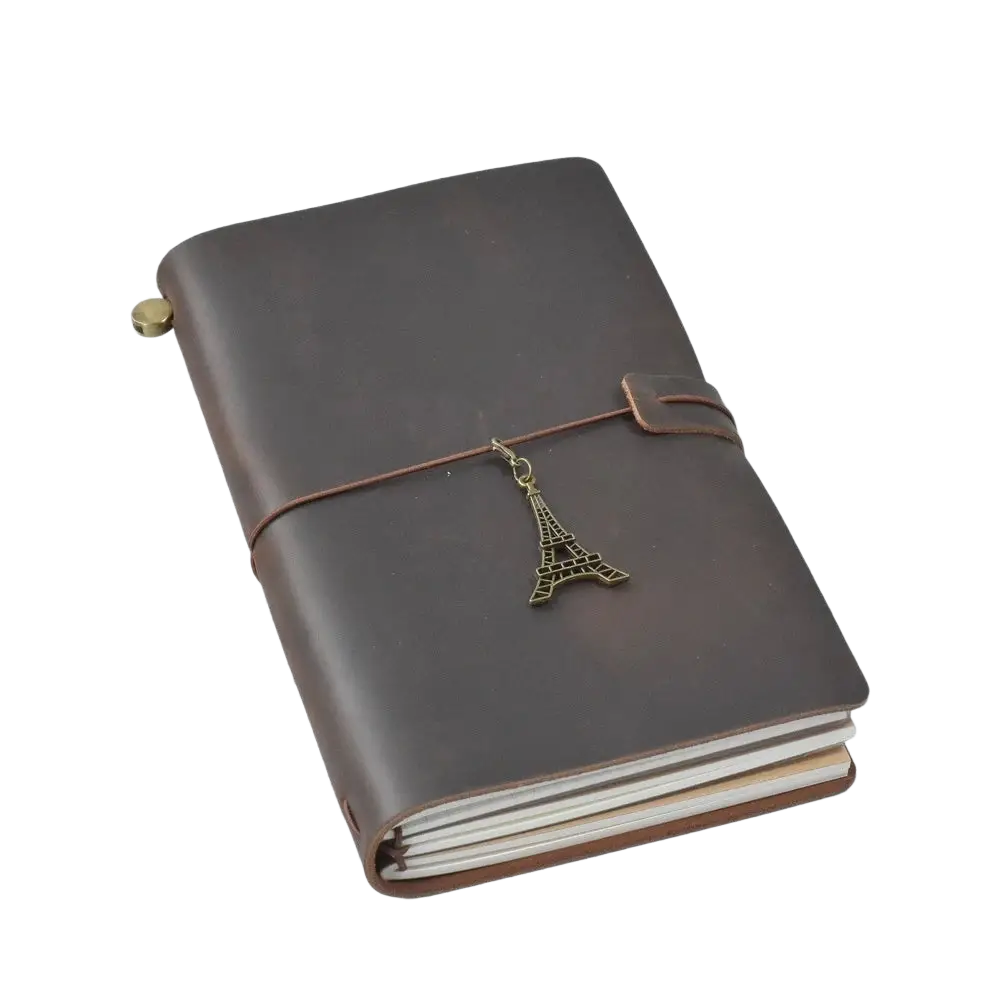 Brown leather-bound refillable travel journal notebook with brass eiffel tower charm on brown twine binding