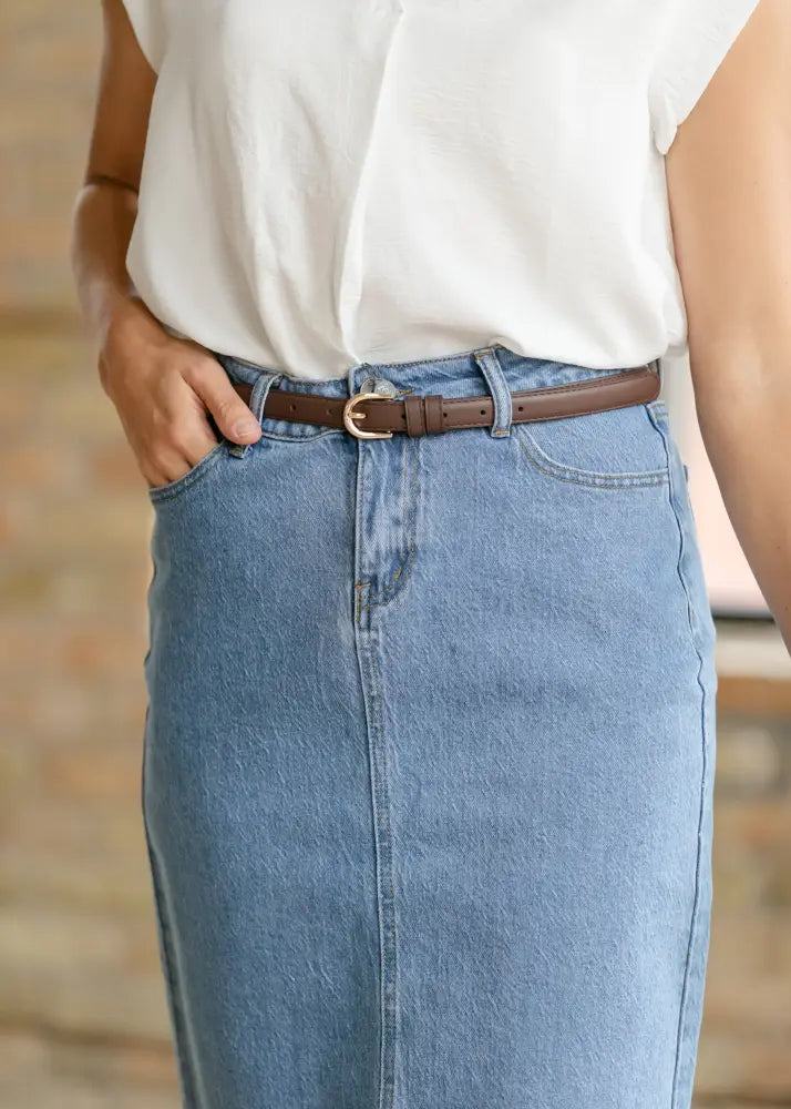 Brown leather belt with gold toned buckle paired with remi classic wash stretch denim midi skirt