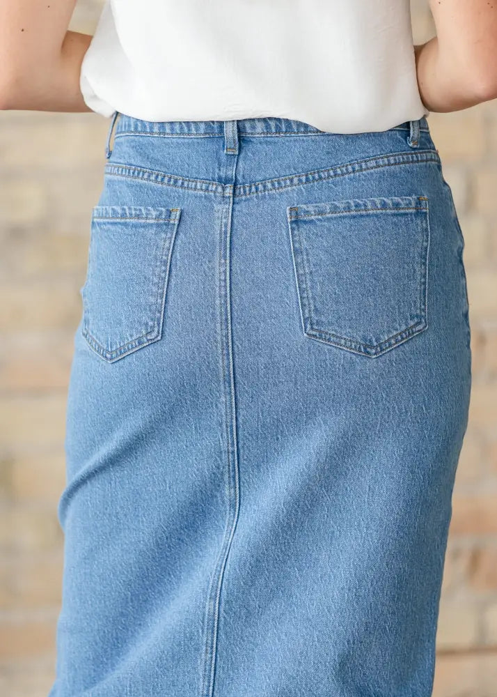 A light blue Remi classic wash stretch denim midi skirt showing the back side with classic pockets and visible stitching