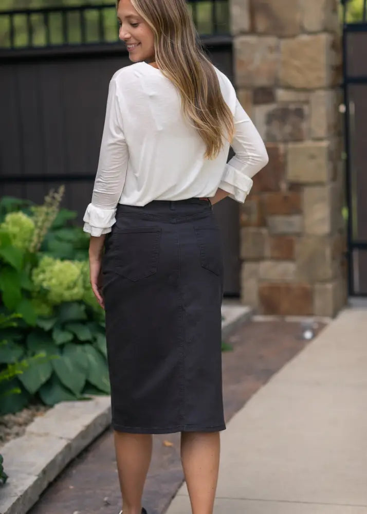 Black knee-length pencil skirt made of stretch denim with no slit shown from the back side