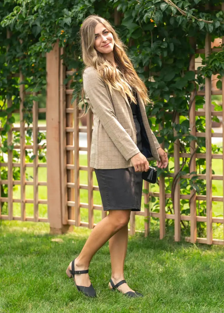 Beige plaid blazer with structured fit and subtle texture worn over dark top paired with remi onyx black no slit stretch denim midi skirt