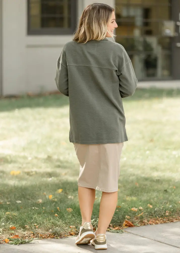 Olive green oversized long-sleeve shirt with ribbed texture paired with taupe stretch denim pencil midi skirt front view