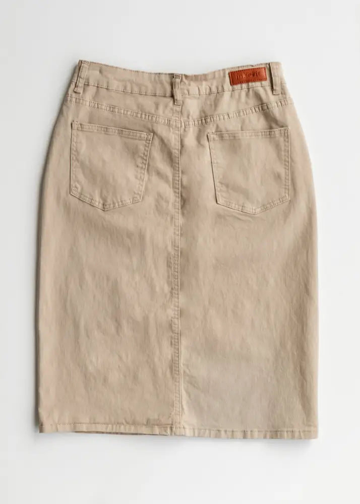 Back view of remi simply taupe stretch denim pencil midi skirt in beige with back pockets and brown leather brand patch