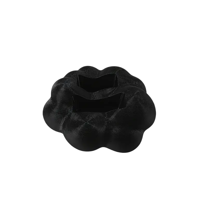 Black 3d-printed cloud shaped remote control holder with textured surface and two rectangular cutouts for desktop use