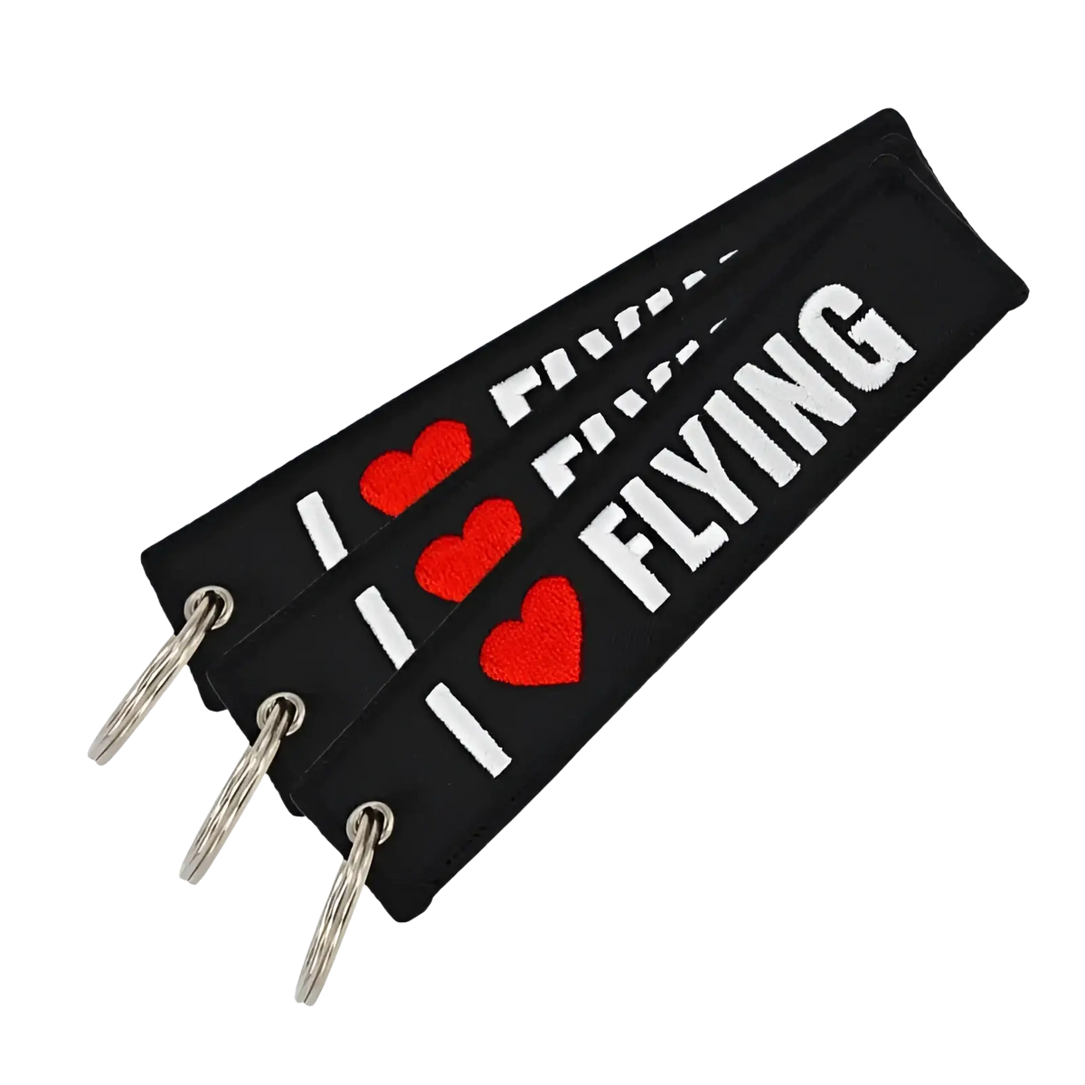 Black fabric Remove Before Flight keychain with embroidered red hearts and white i heart flying text