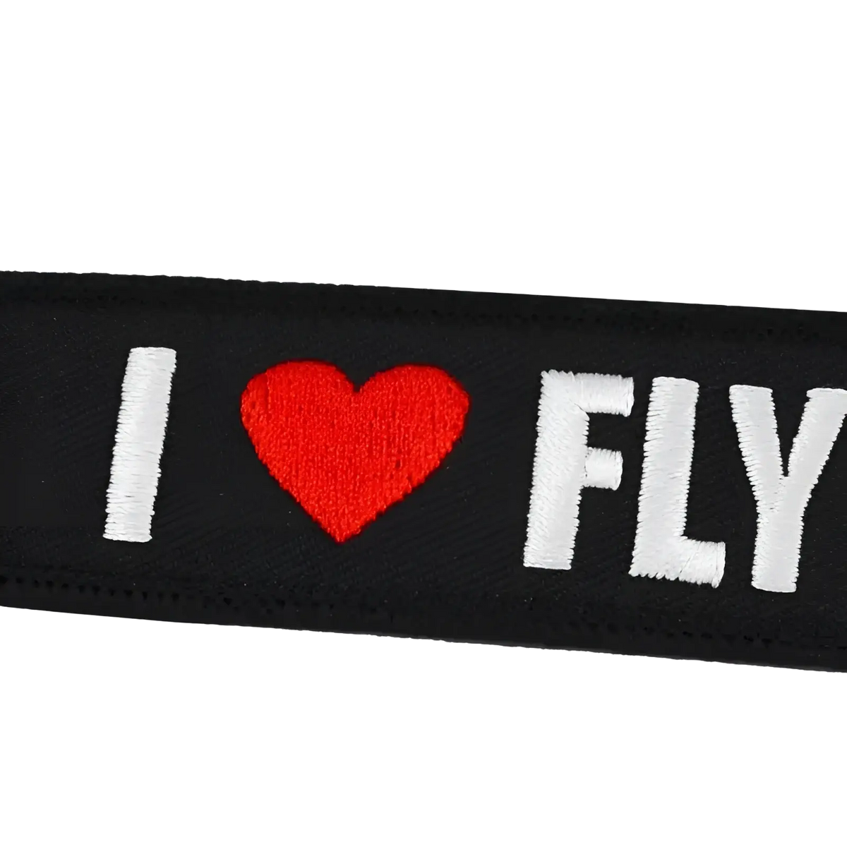 Black embroidered patch keychain with white i heart fly lettering and red heart symbol for remove before flight use