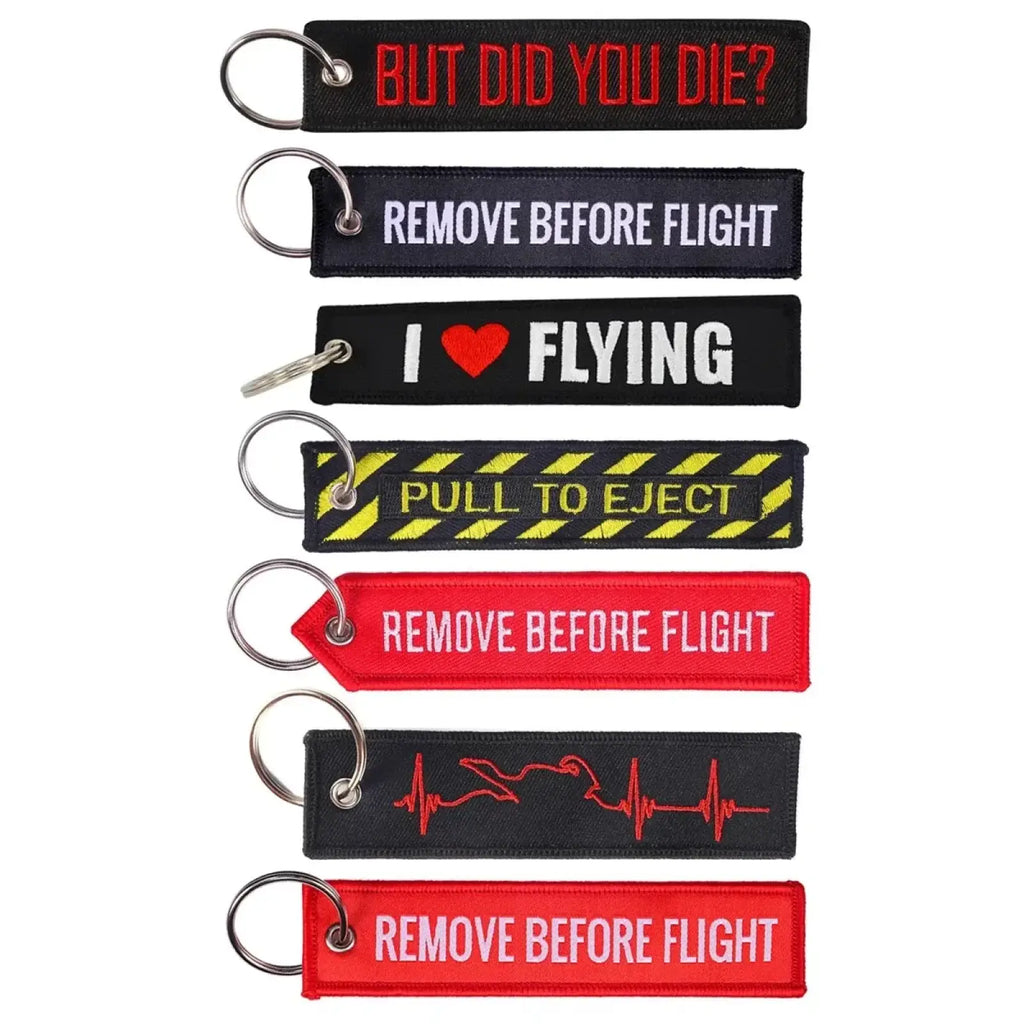 Remove before flight embroidered keychains in black and red with aviation phrases and metallic rings for aviation enthusiasts