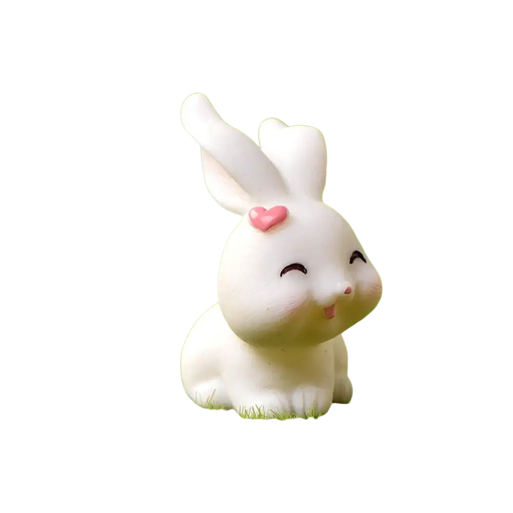 White ceramic resin bunny figurine with pink heart on ear sitting on grass for easter garden and cake decor