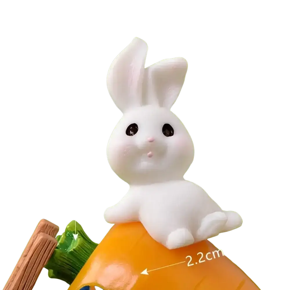 A white glossy resin bunny figurine with black bead eyes on an orange carrot base for easter garden decor