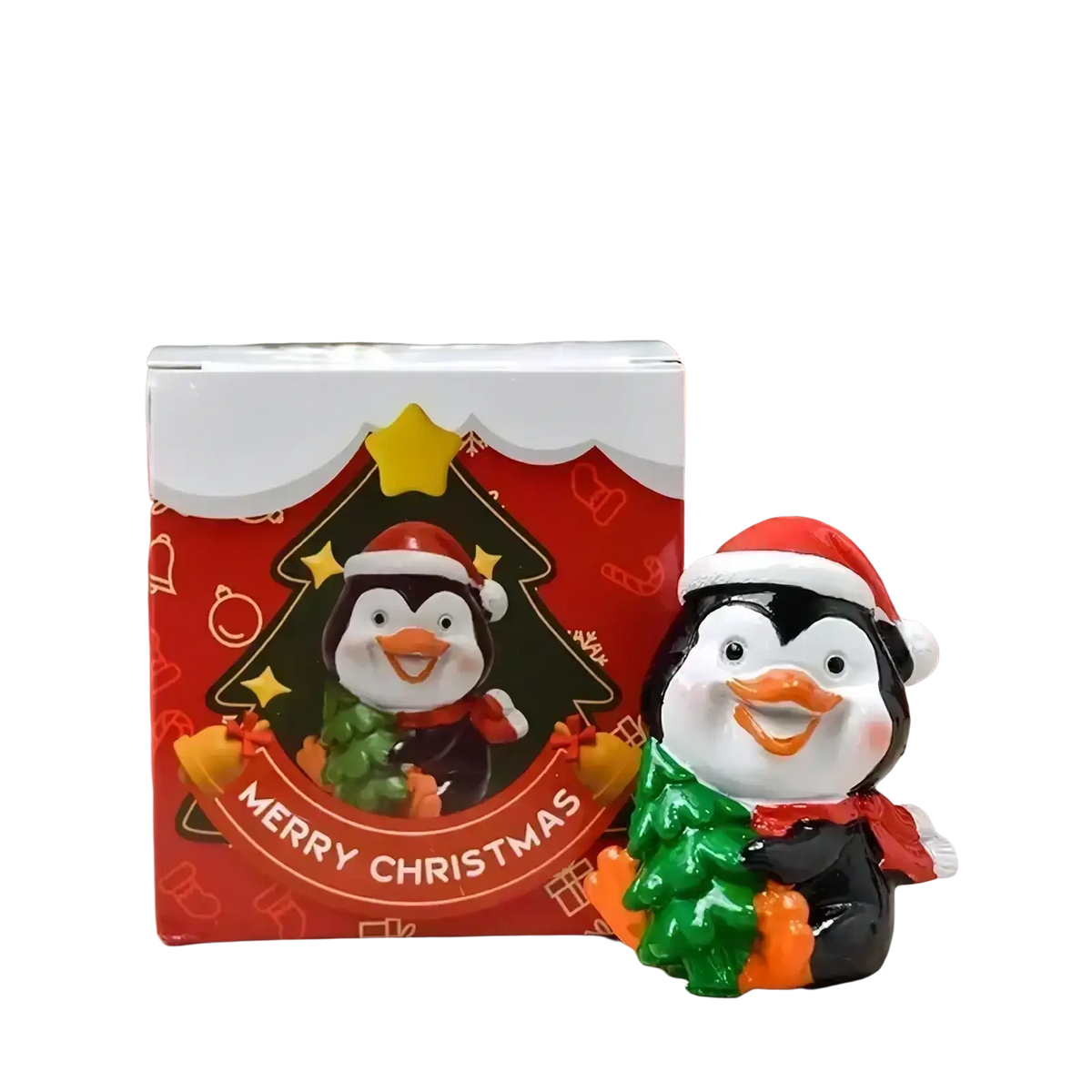A cheerful black and white resin penguin figurine wearing a red santa hat holding a green tree for holiday desktop decor