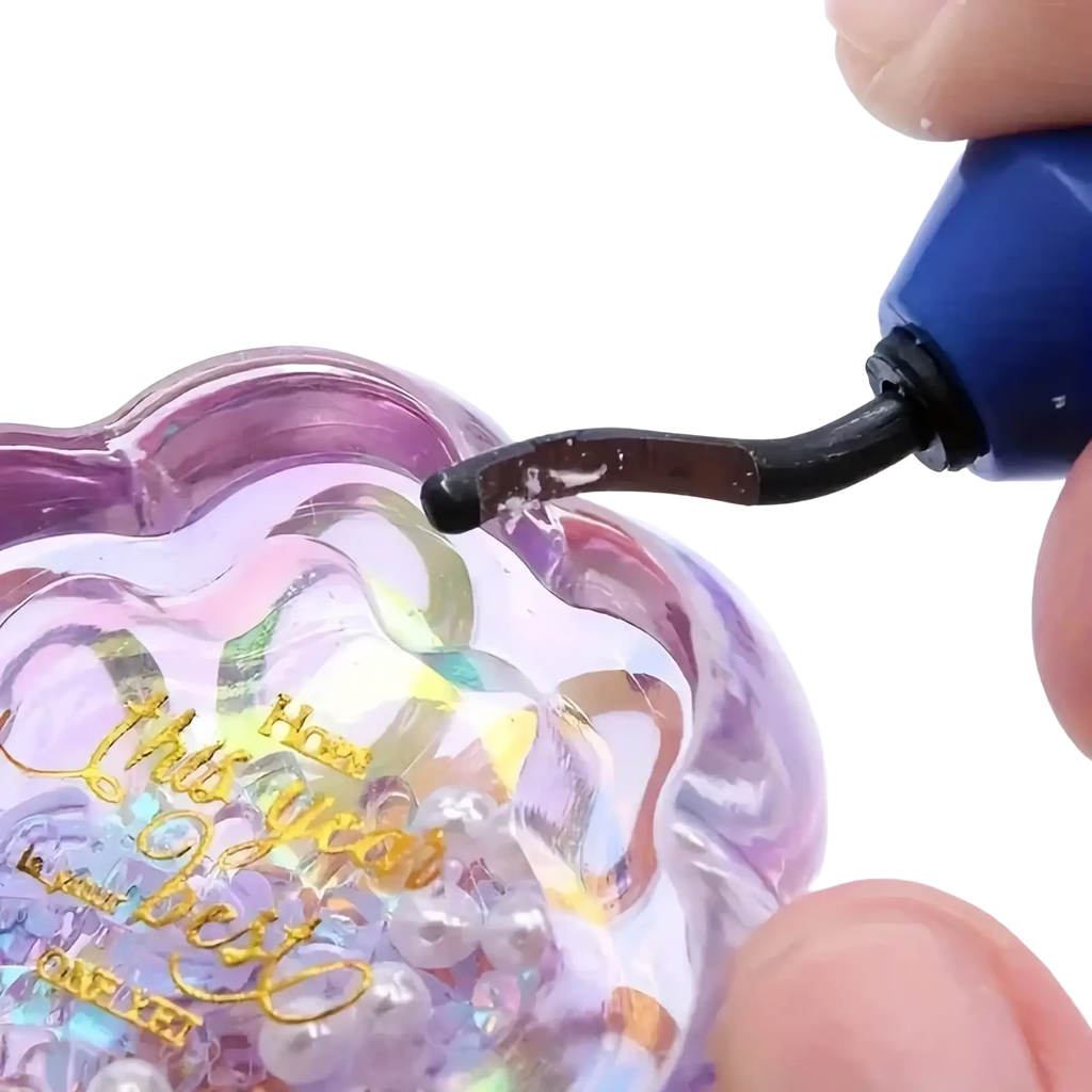 Translucent purple heart-shaped resin epoxy trimming tool container filled with iridescent beads and gold foil lettering