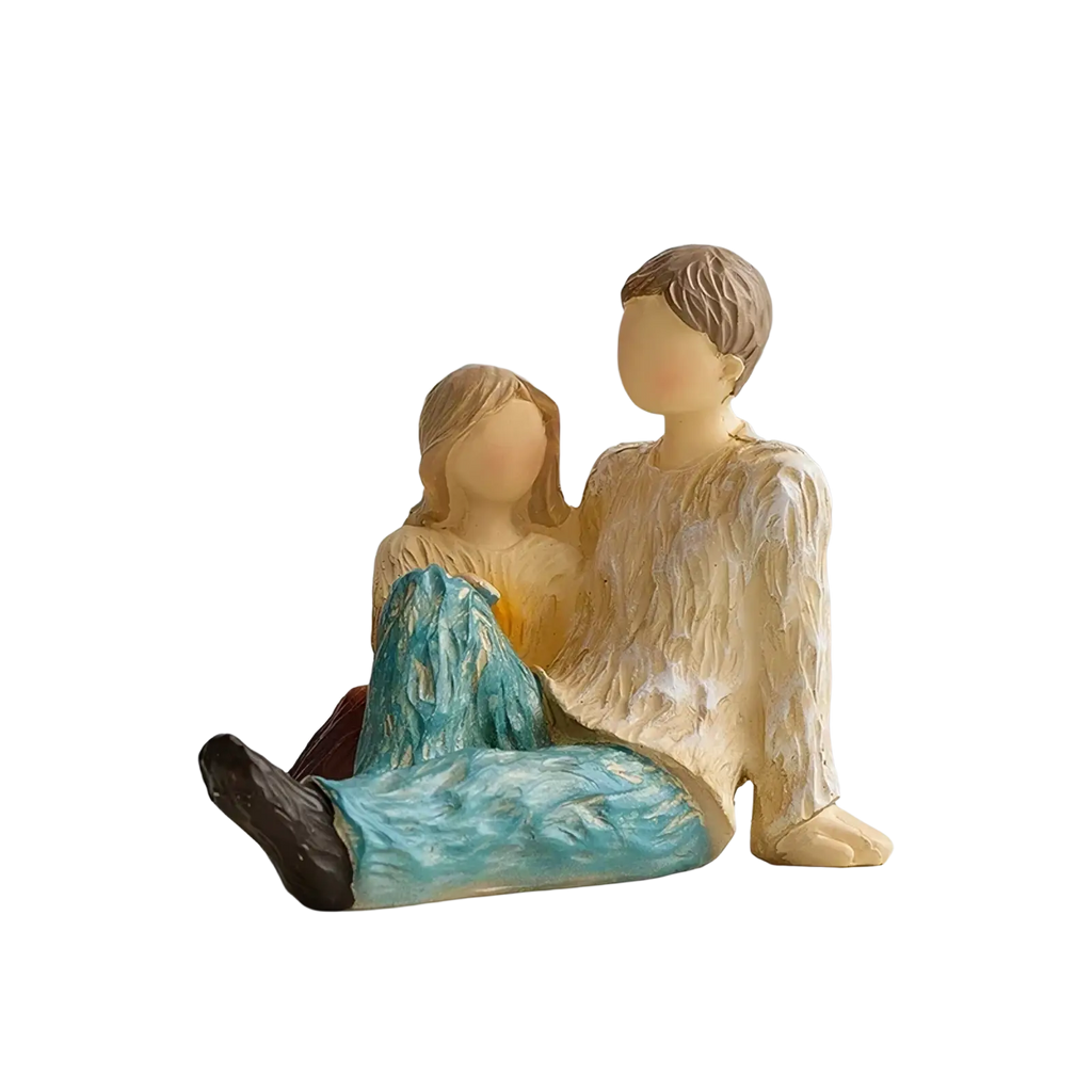 Cream-colored resin family figurine abstract art home decor of couple sitting with turquoise pants and beige shirt