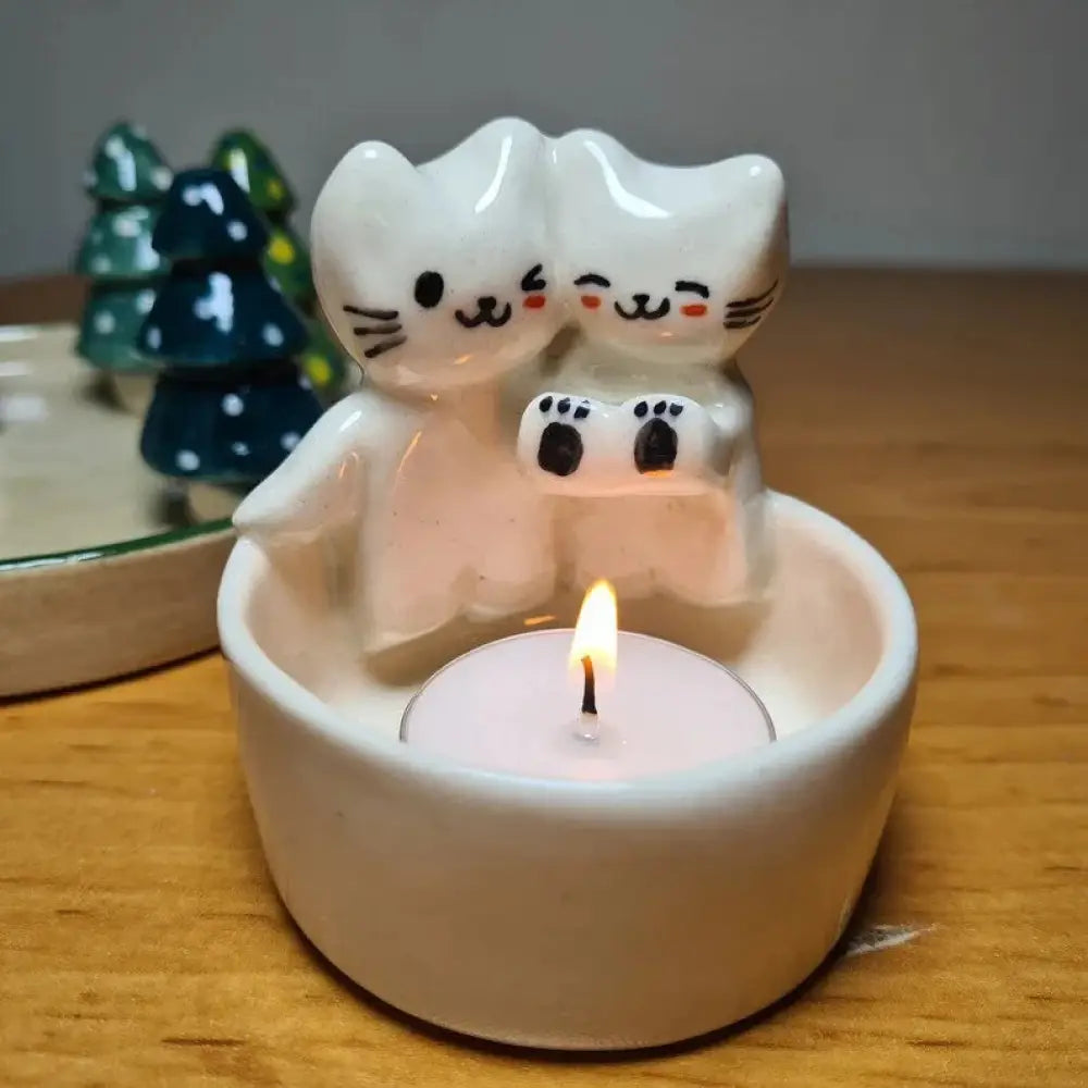 Handcrafted cuddling kittens ceramic candle holder in white with black facial details and paw prints