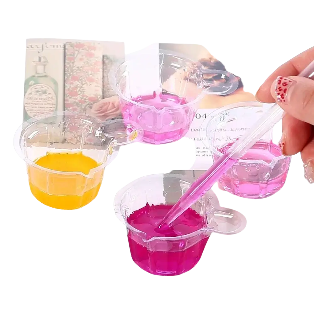 Clear plastic measuring cups with vibrant pink yellow and magenta liquids in resin mixing casting tools kit for jewelry making