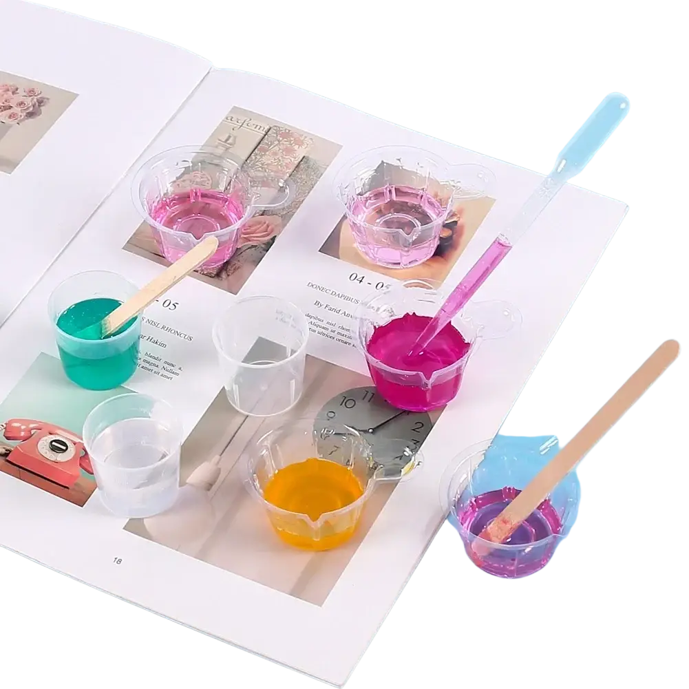 Clear plastic cups with colorful liquids and wooden stirrers in a resin mixing casting tools kit for jewelry making
