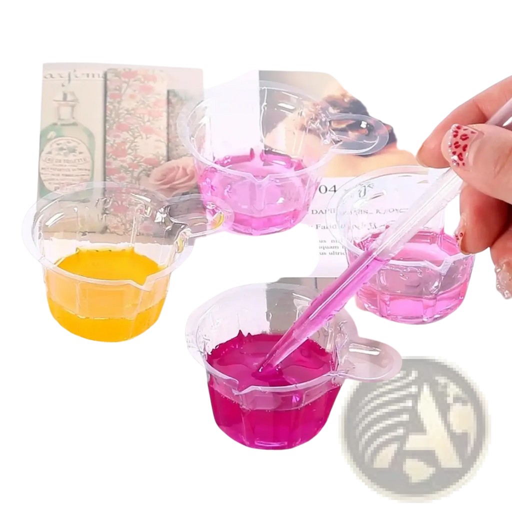 Clear plastic measuring cups with vibrant pink yellow and magenta liquids in resin mixing casting tools kit for jewelry making