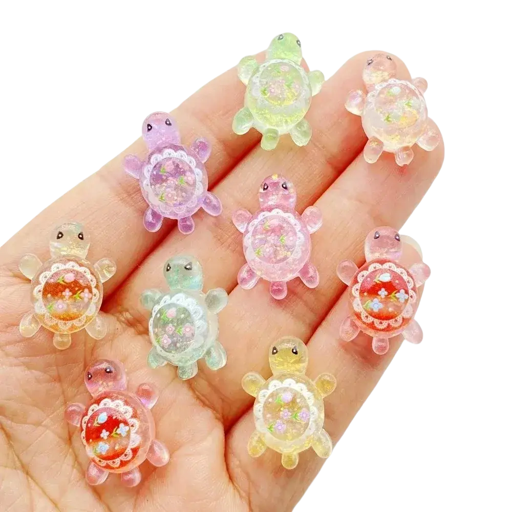 A collection of colorful translucent resin turtle flatback charms with intricate floral designs inside shells 10 pack