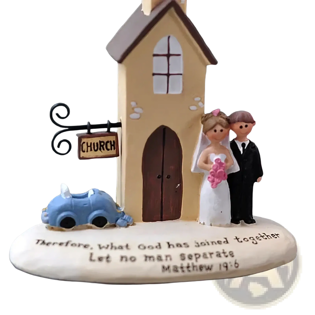 Beige resin wedding church figurine with bride in white and groom in black standing by blue car under church sign