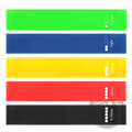 Set of five colorful resistance loop bands in green blue yellow red and black with printed weight indicators for fitness
