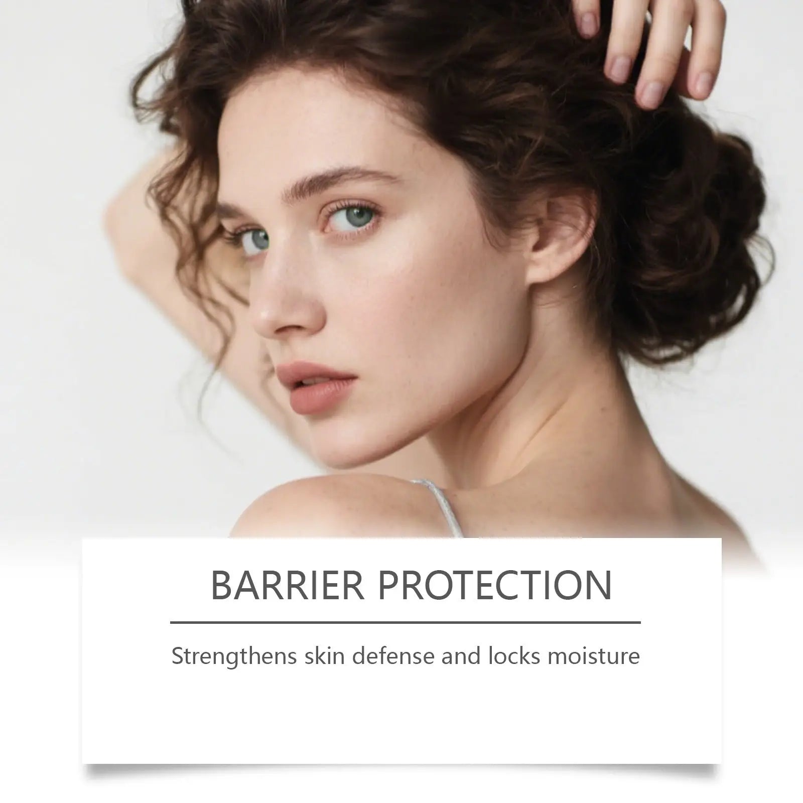 A woman with dark curly hair and light eyes wearing a silver strap top with retinol firming cream gold booster shot
