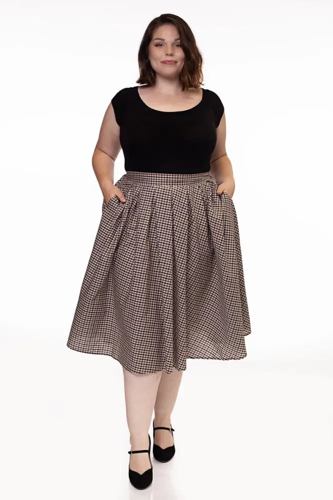 Black cap sleeve retro boat neck top paired with a black and beige checkered a-line skirt with flared silhouette