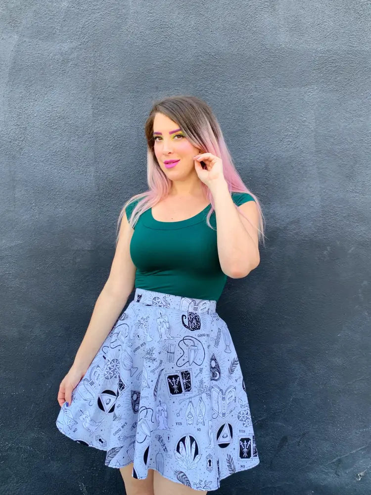 A light blue a-line skirt with black ink-style occult symbols paired with a hunter green retro boat neck top