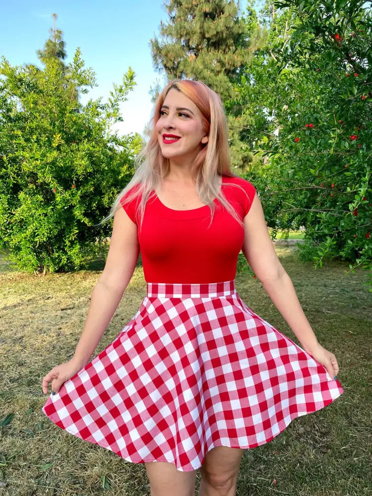 A vibrant red and white gingham skirt with a flared a-line silhouette paired with a vintage red boat neck cap sleeve top