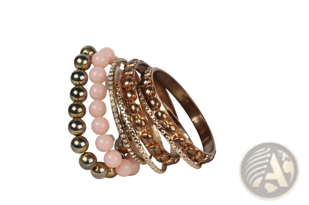 A retro gold and pink rhinestone bangle bracelet set featuring rose gold and pink beaded smooth and textured designs